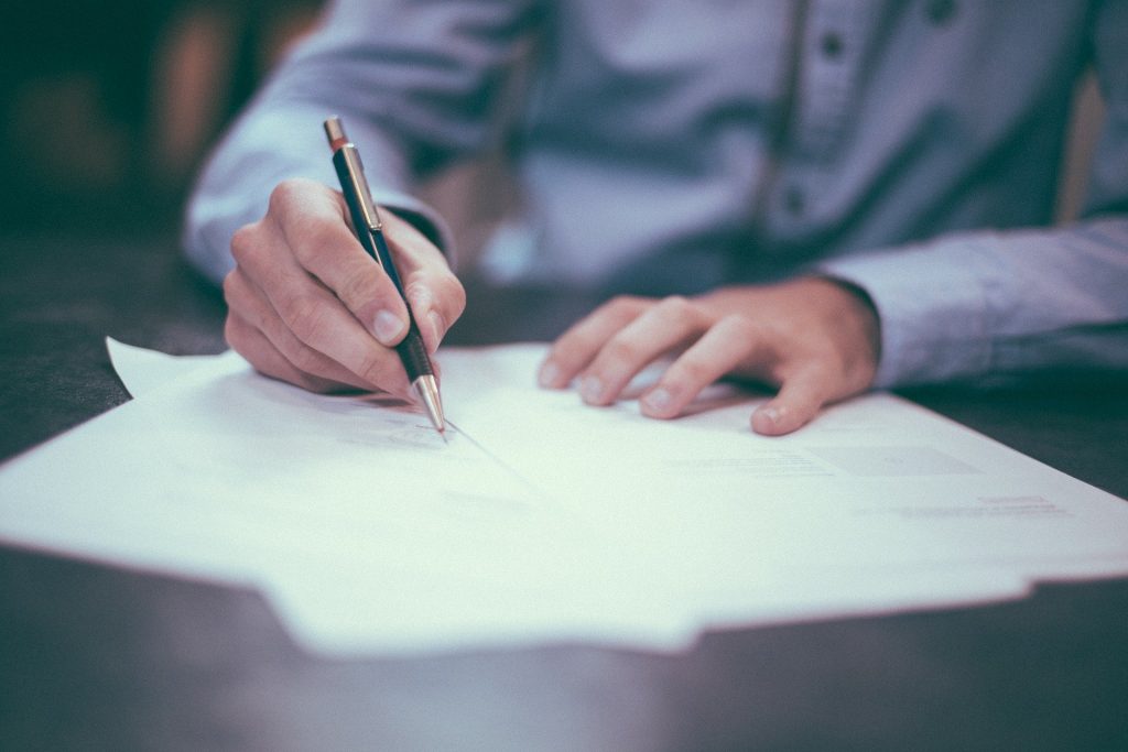 How to promote your business and increase the productivity level? A person using a pen on papers